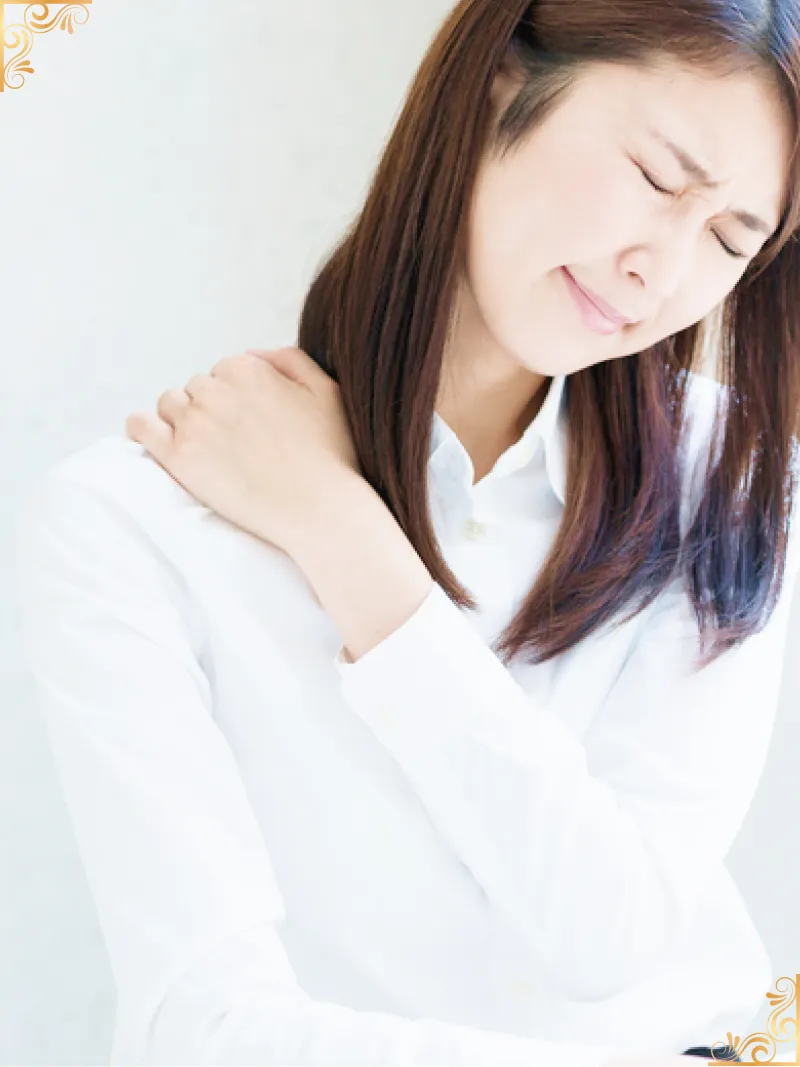 肩に手を当てて痛がる女性